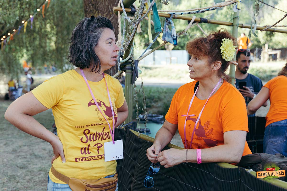 Deux femmes bénévoles à Samba al país discutant autour d'un comptoir